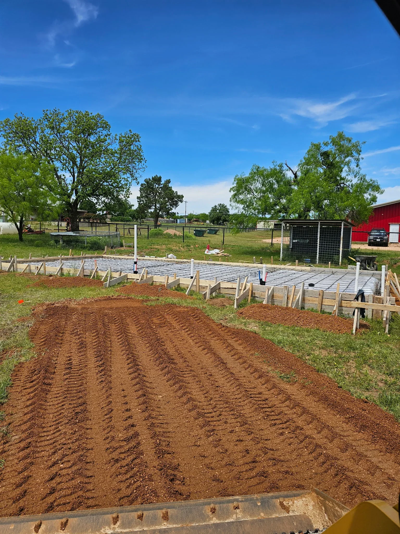 Concrete pad foundations for raised garden beds with wooden frame borders on prepared soil