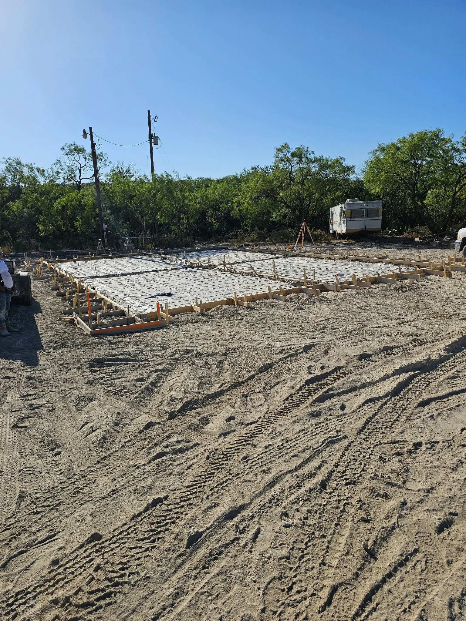 Concrete slab foundation with rebar grid and wooden forms on prepared base
