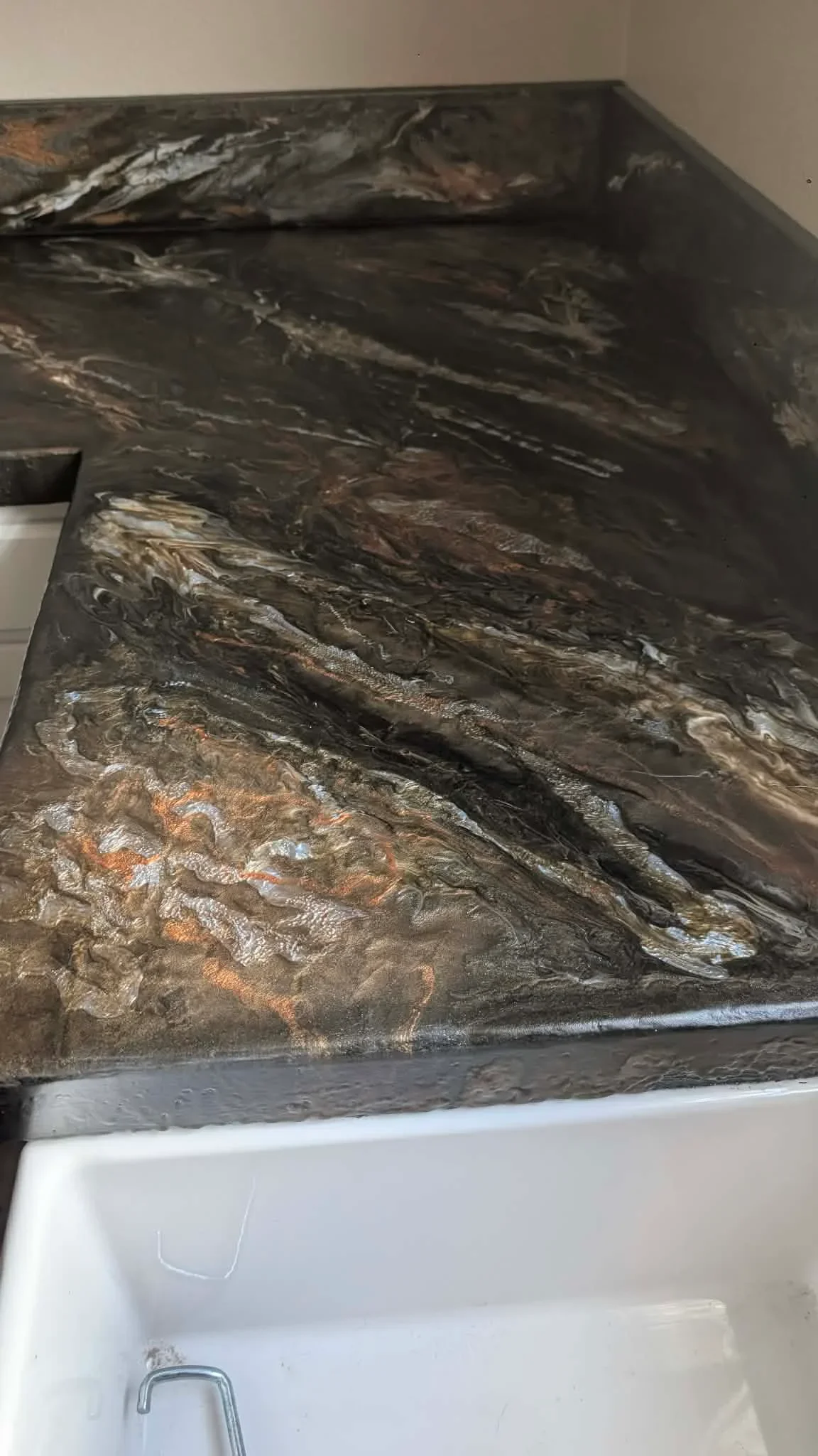Dark concrete countertop with bronze and silver metallic swirls and polished finish