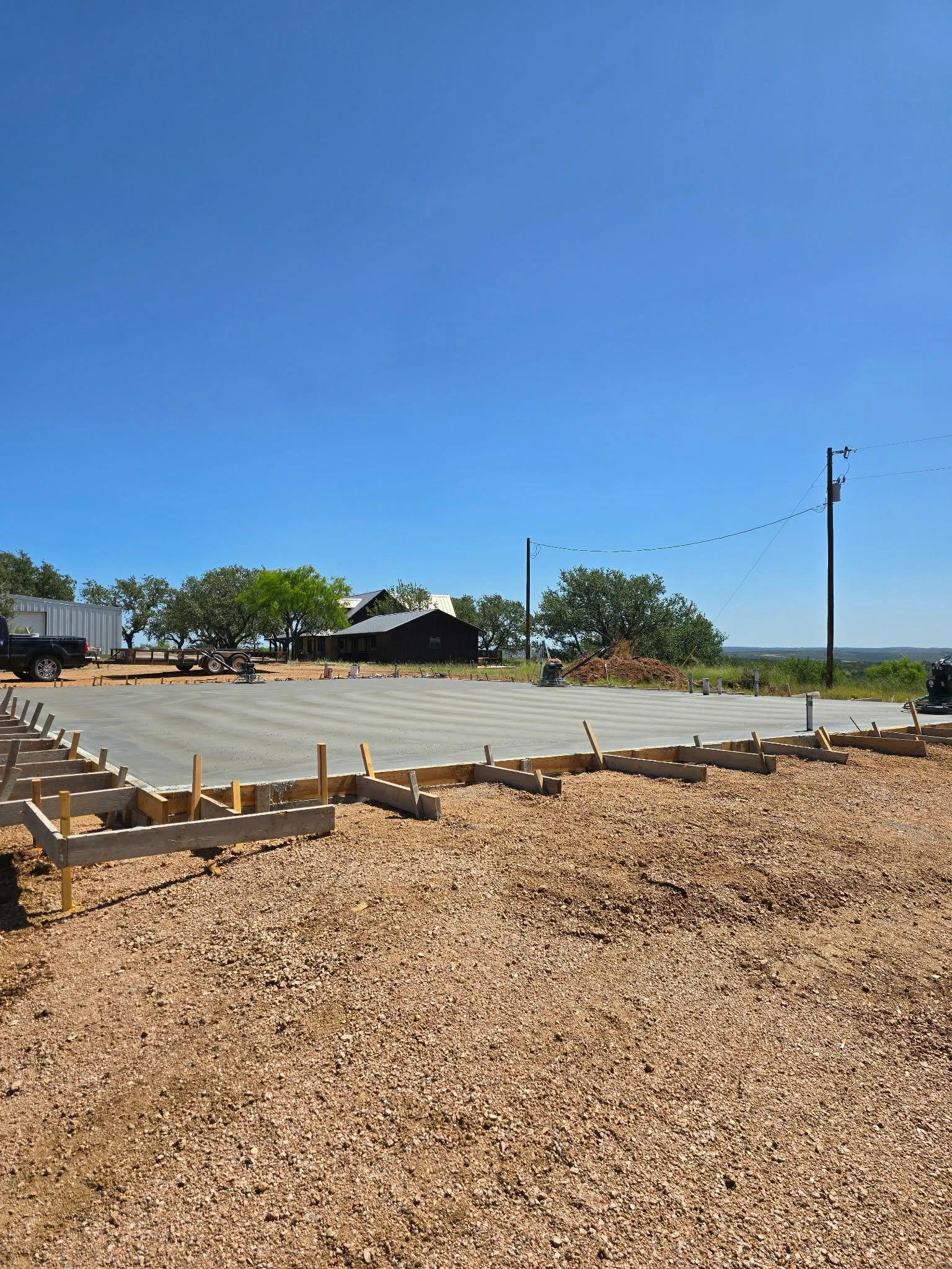 Finished concrete foundation pad with wooden perimeter forms and gravel base preparation